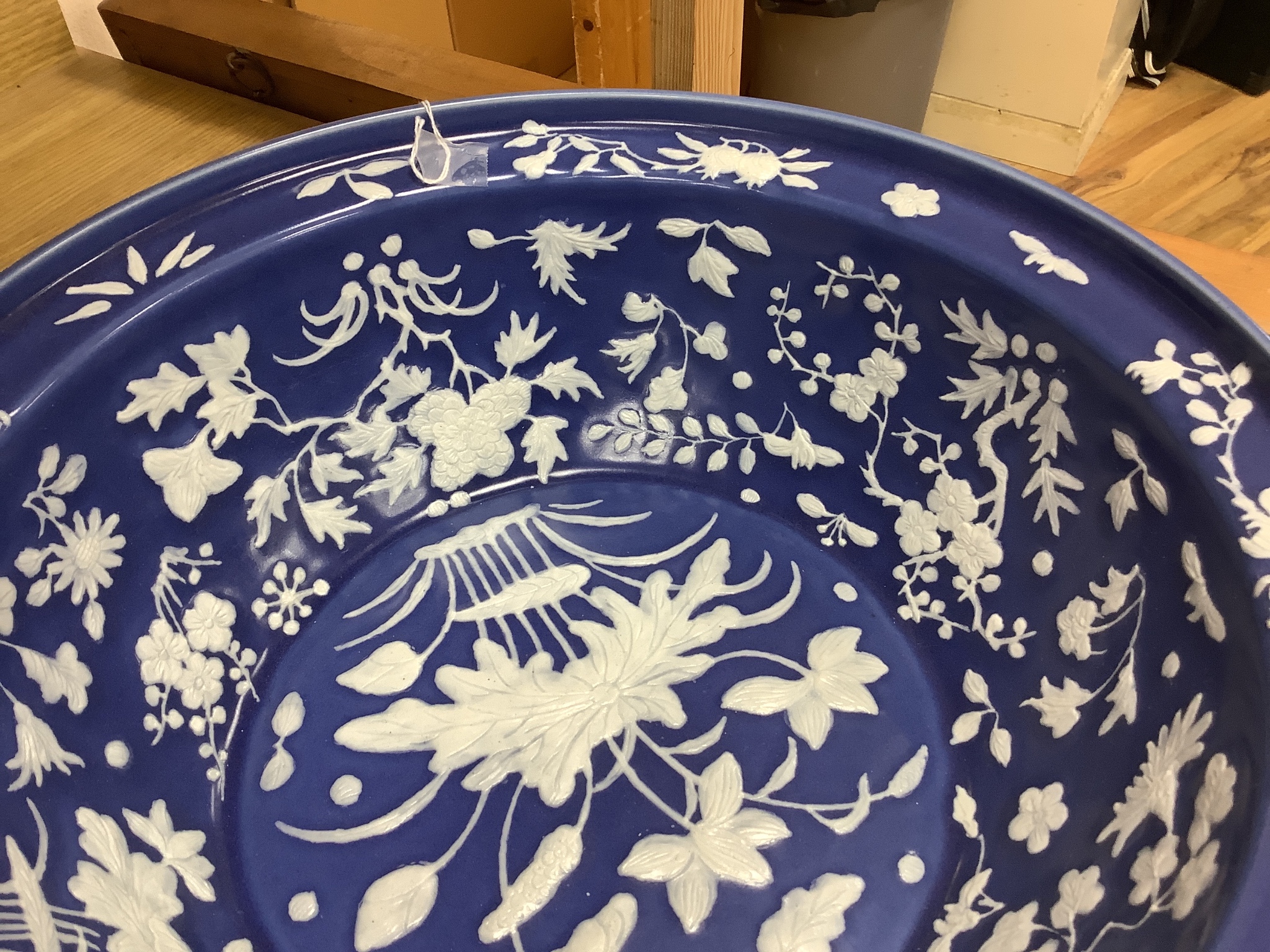 A large Chinese blue and white porcelain basin, lightly relief moulded with plants, 40cm